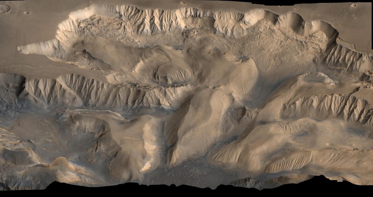 A huge canyon system cut across the rusty ground of Mars