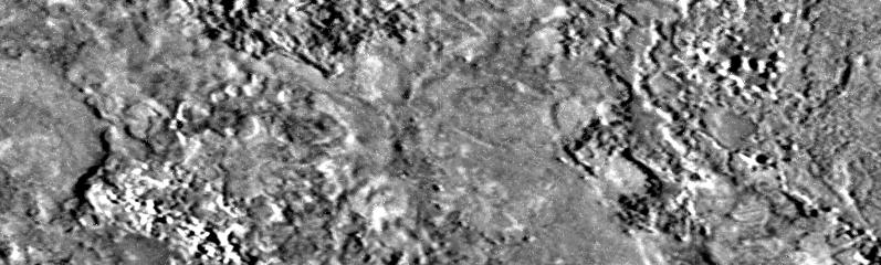 A close gray view of Io's rough, mottled surface