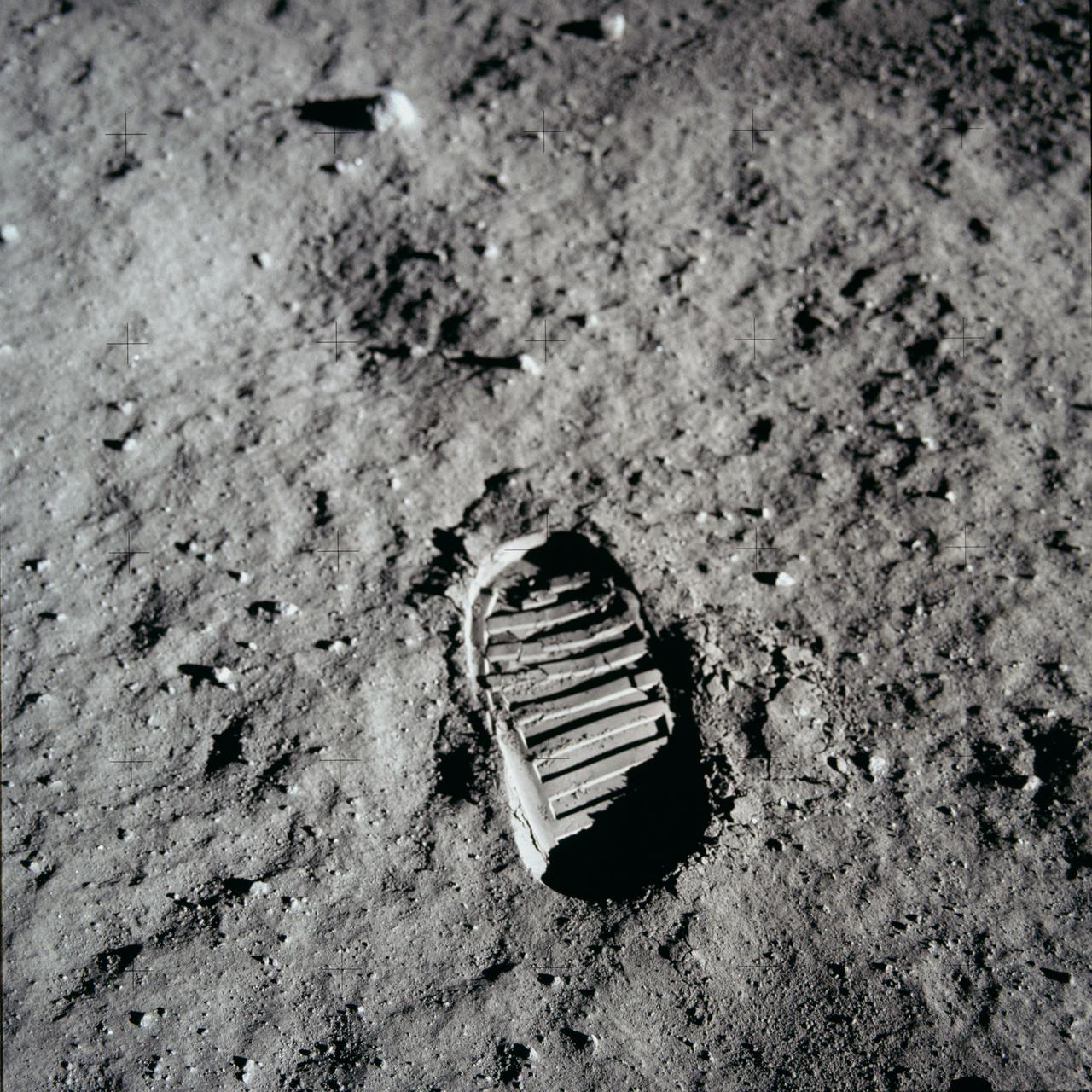 A boot print in gray Moon dust, with small plus-shaped camera marks