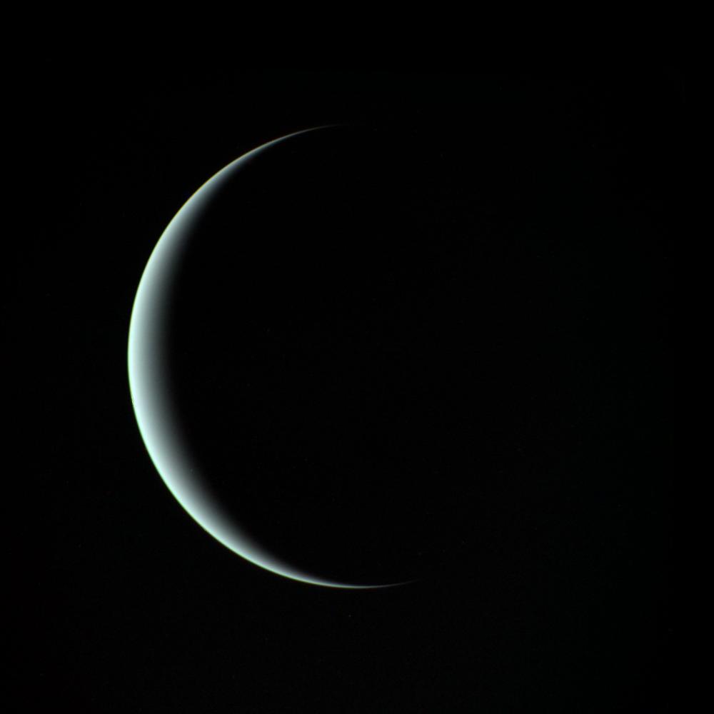 Uranus as a thin pale crescent against black space
